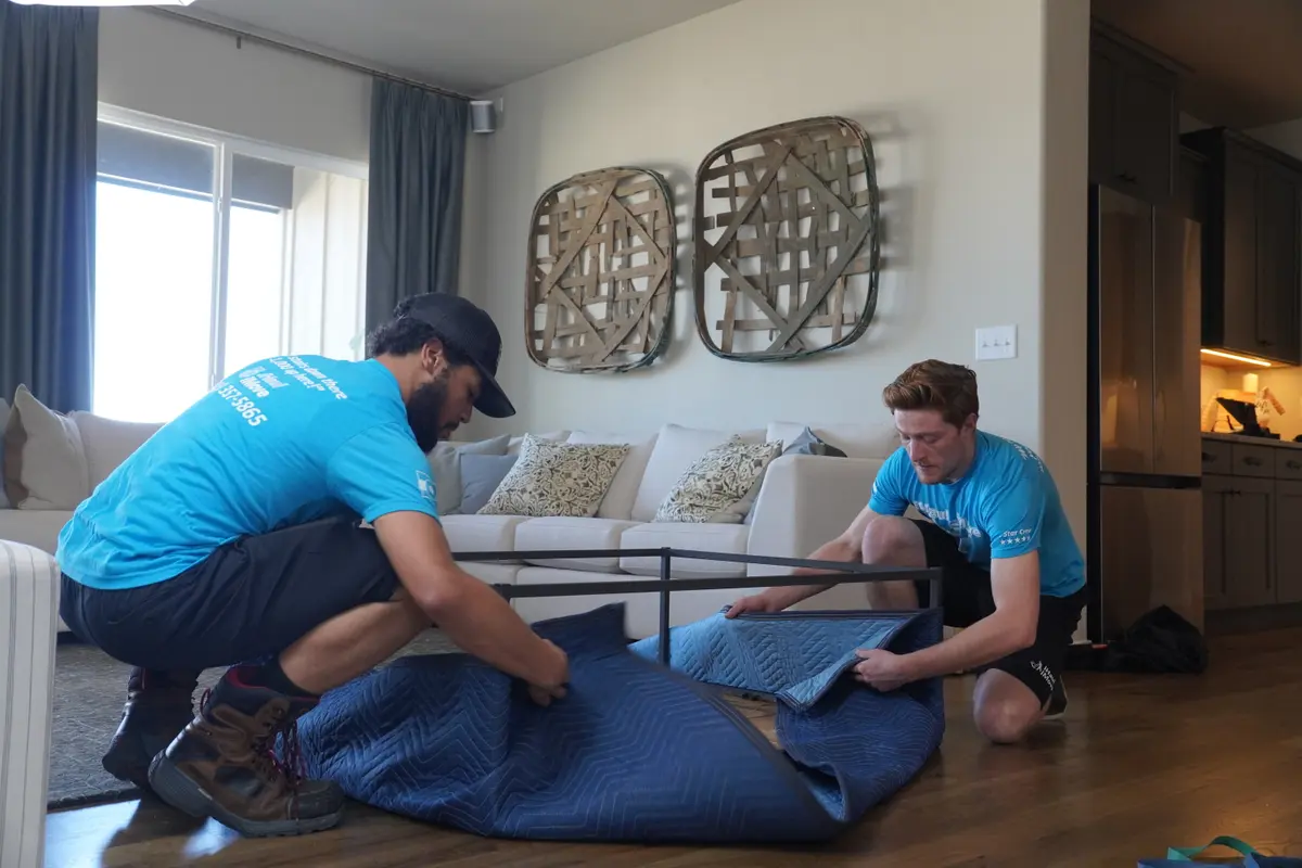 Movers professionally wrapping a conference table