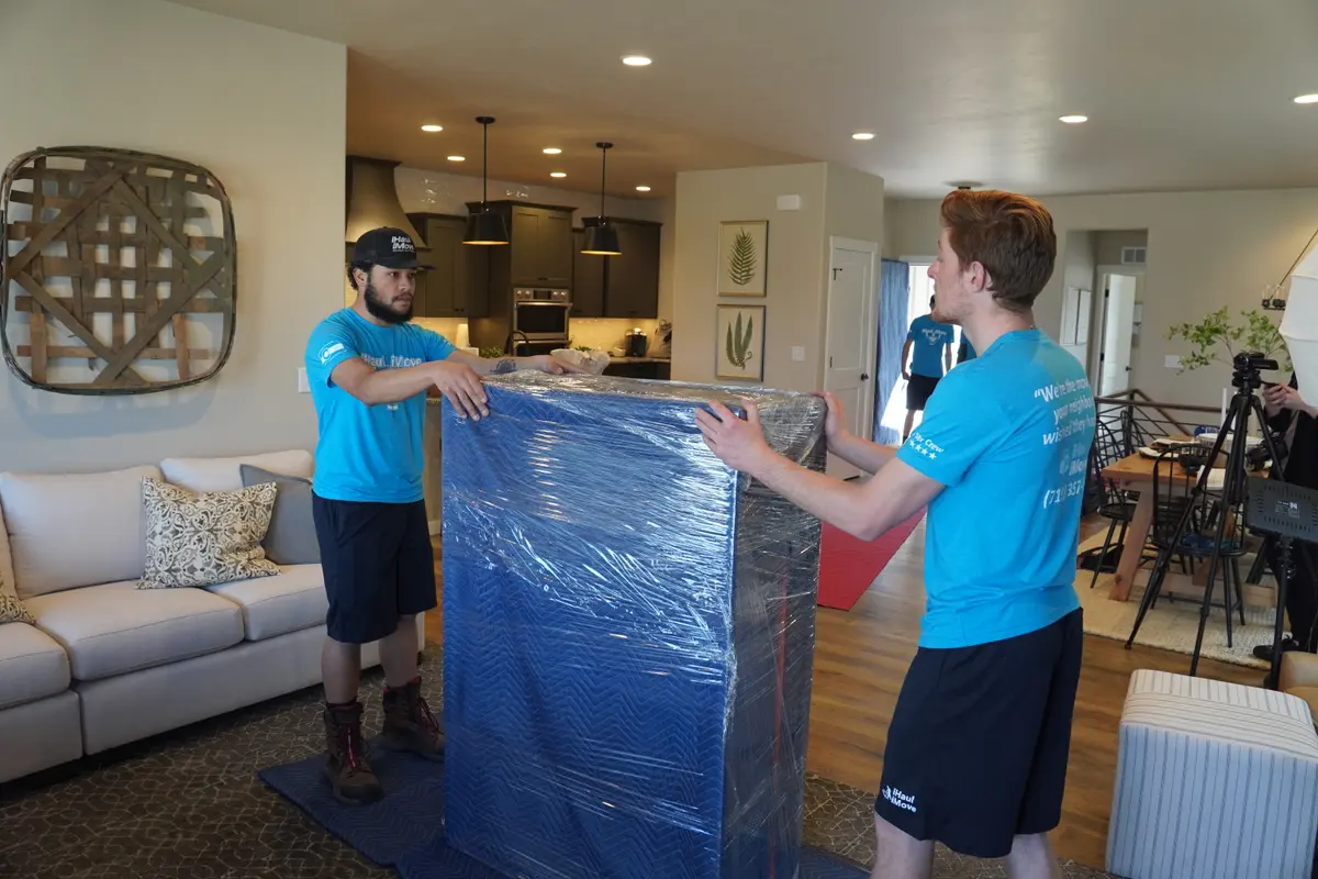 Professional mover wrapping furniture with protective padding
