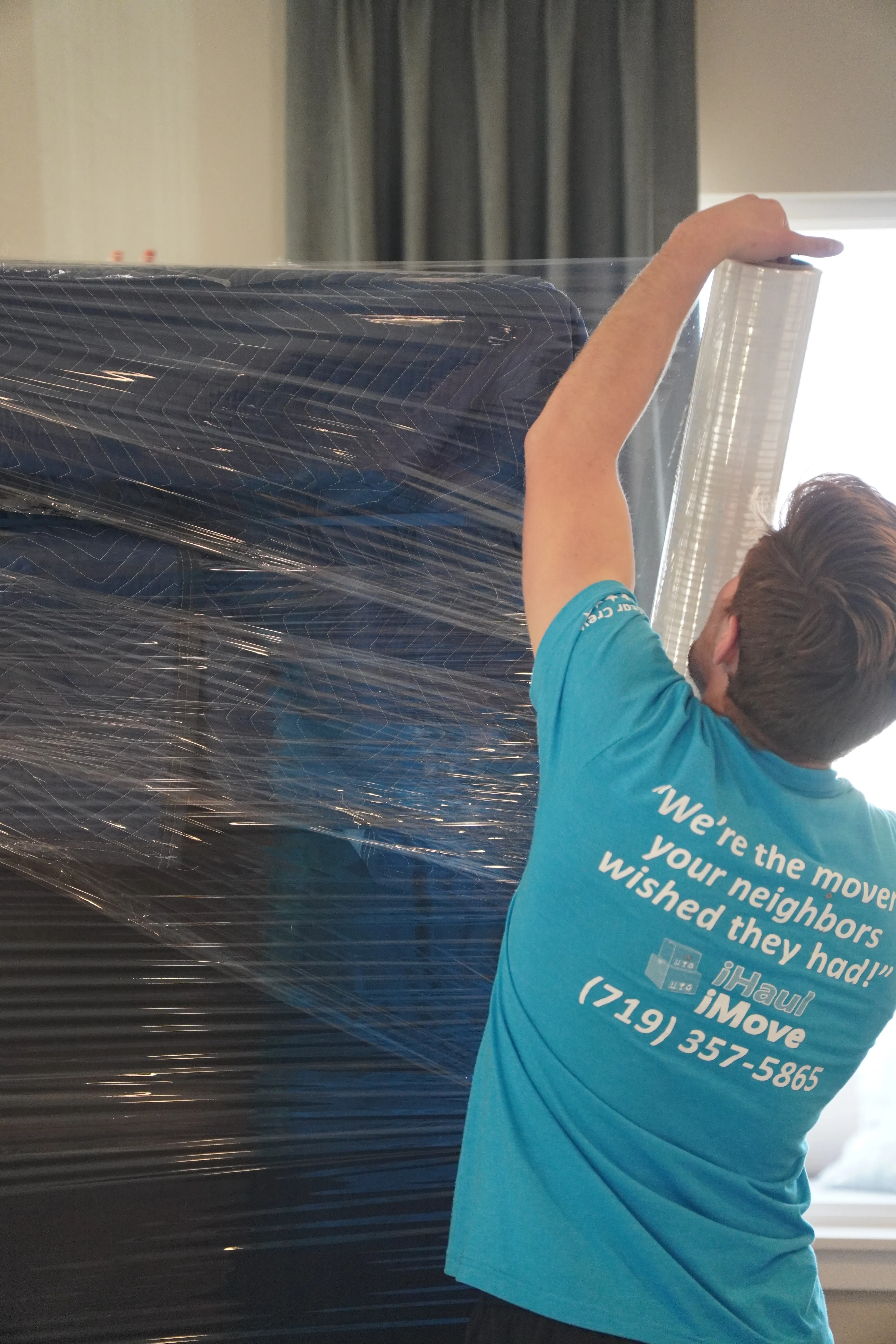 Professional mover carefully wrapping furniture