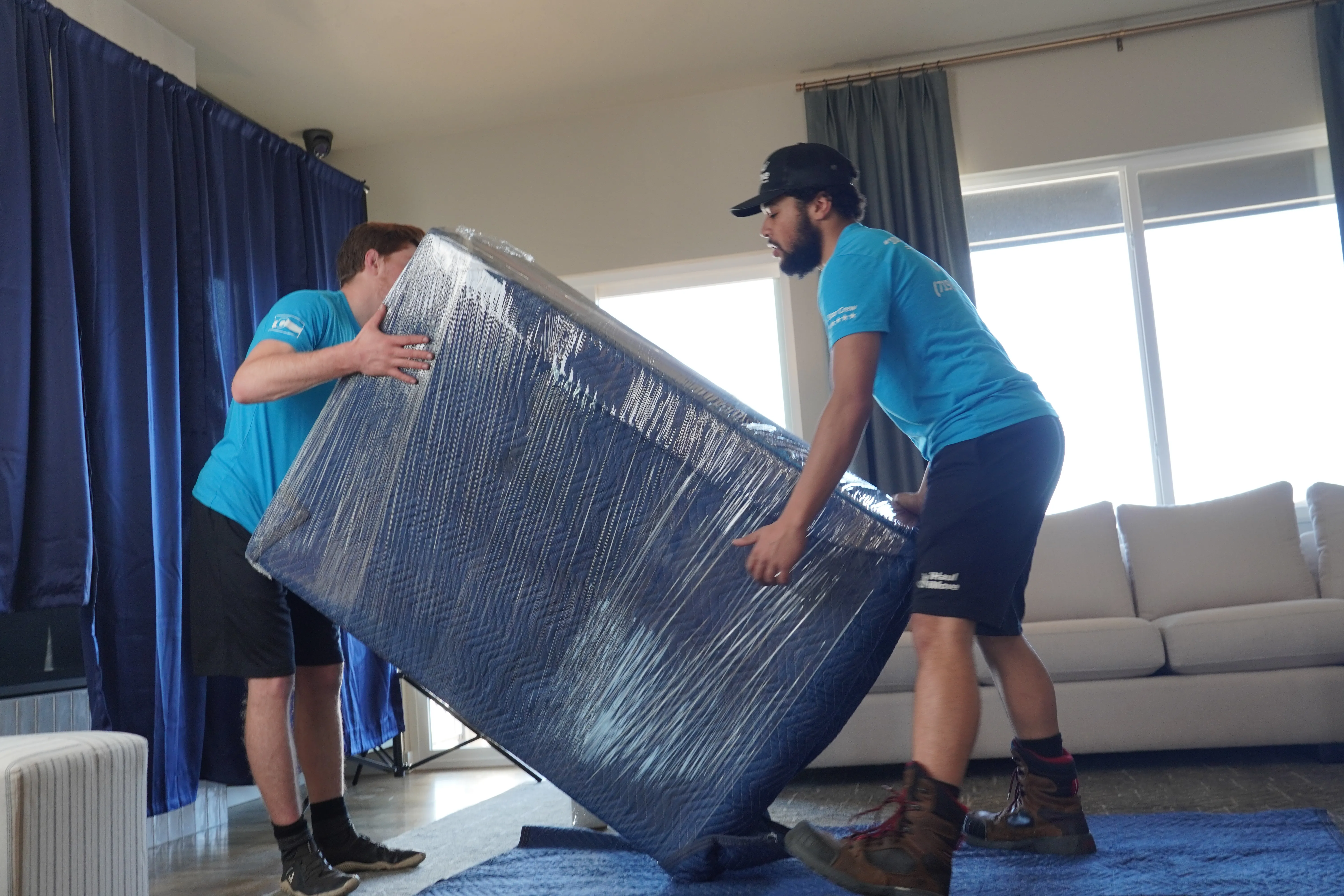 Professional movers carefully lifting furniture